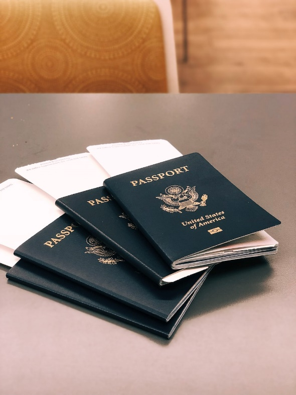 four passports on the table with tickets tucked between their pages