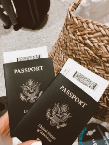 a person holding two passports with tickets tucked between the pages