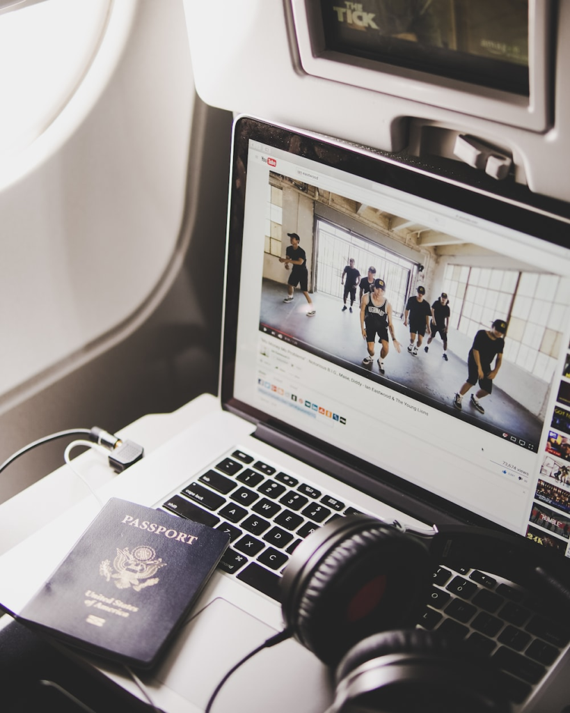 an American passport on the edge of a laptop on a plane