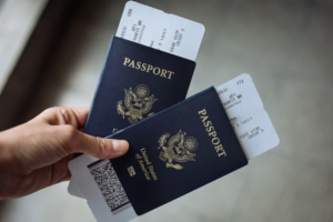 a person holding two passports with tickets tucked inside each of them