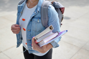 a person holding binders and journals