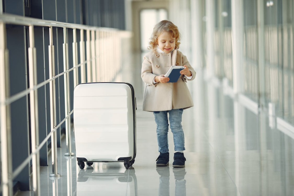 A little girl with a passport and luggage