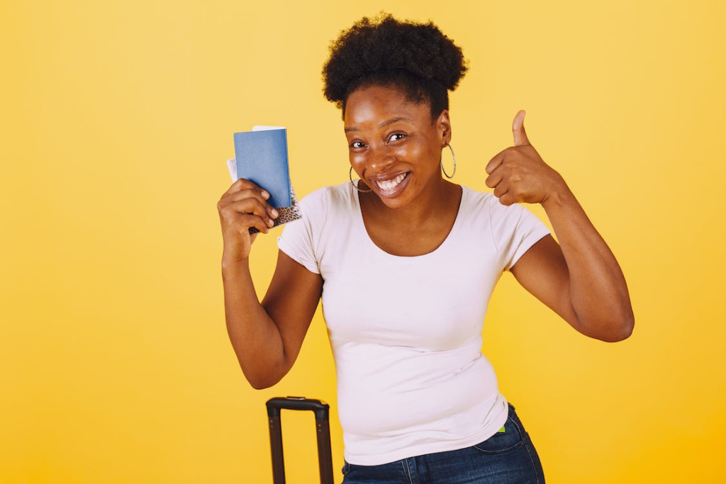 A woman smiling with a passport in her hand