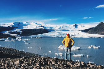 a man standing near a frozen lake