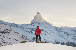 traveler atop a snowy mountain