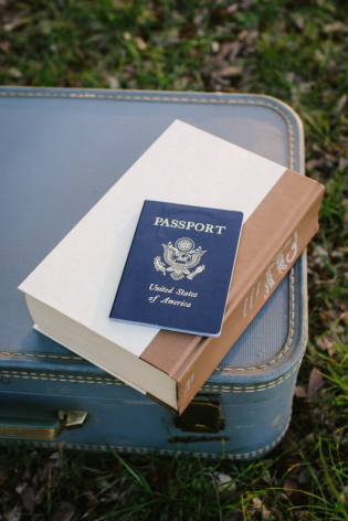 A photo showing a passport resting on top of a suitcase.