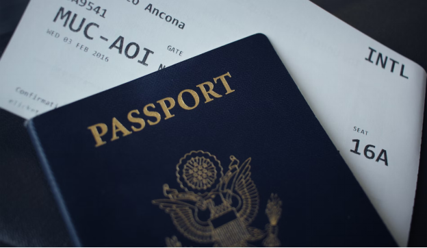 A photo showing a passport resting on top of a flight ticket.