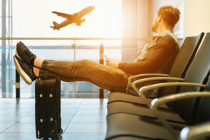 A photo showing a person watching a plane from an airport window.