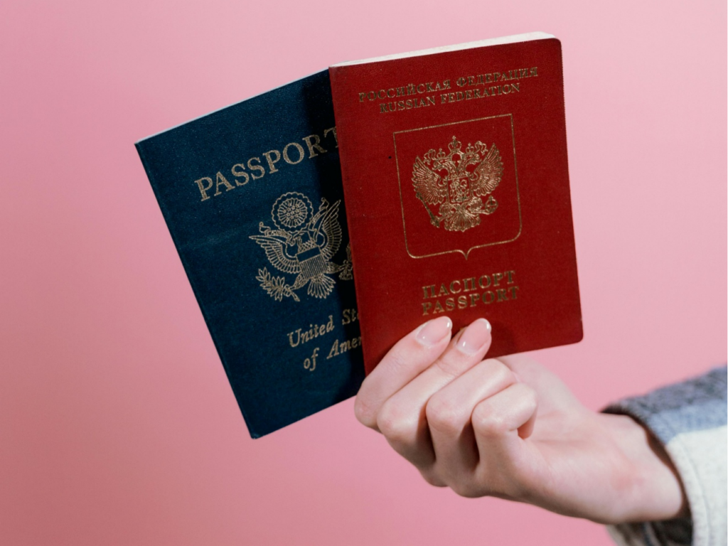 Cropped person holding two passports in hand