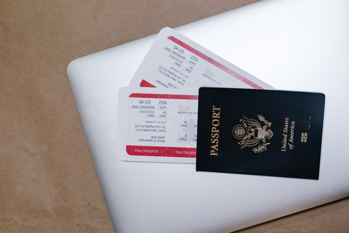 An American passport with boarding pass and laptop
