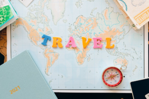 Travel in funky letters placed on a world map alongside a campus