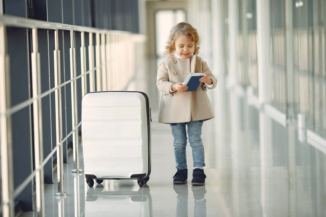 A child holding a passport at an airport