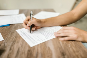 A person filling out a passport application in an office.