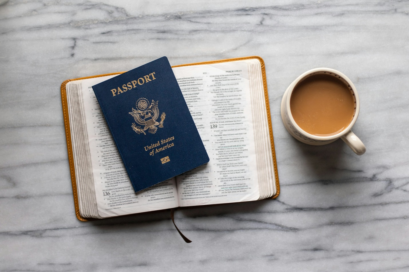 A cup of tea placed next to a book. 