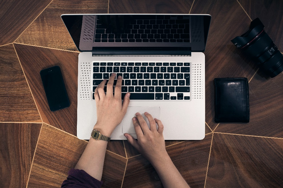 A person typing on a laptop keyboard.