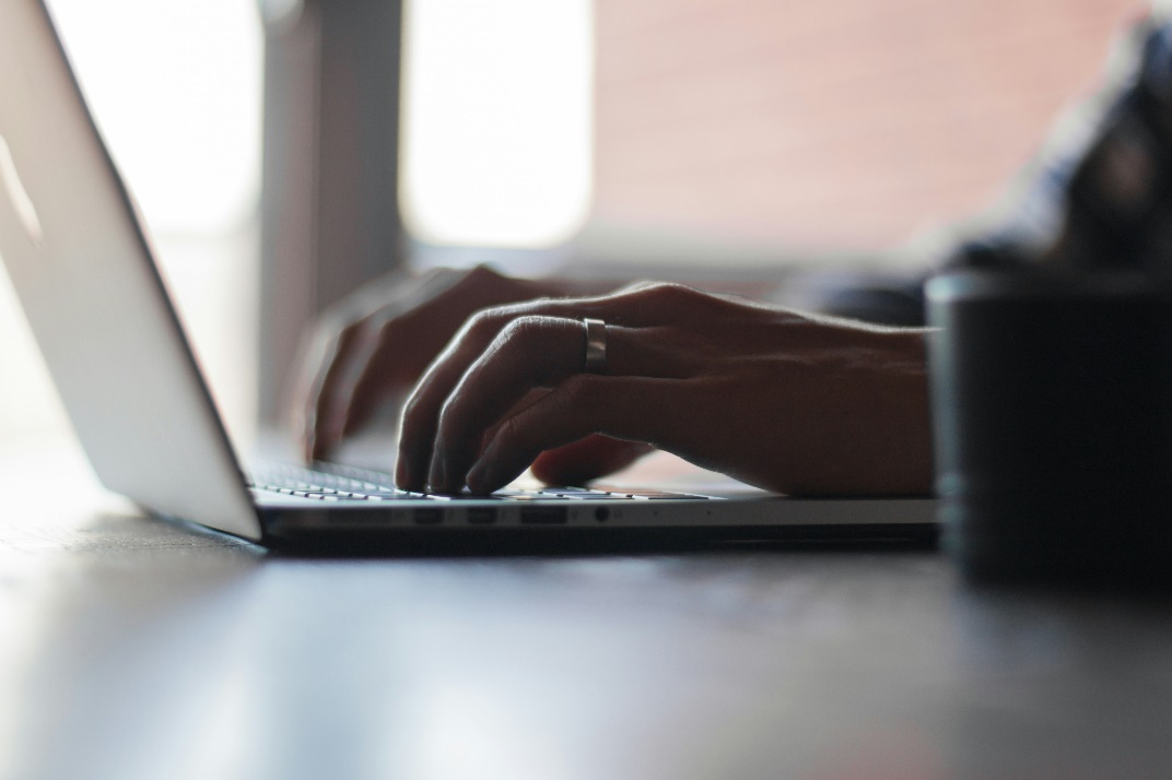 A person typing on a laptop keyboard.