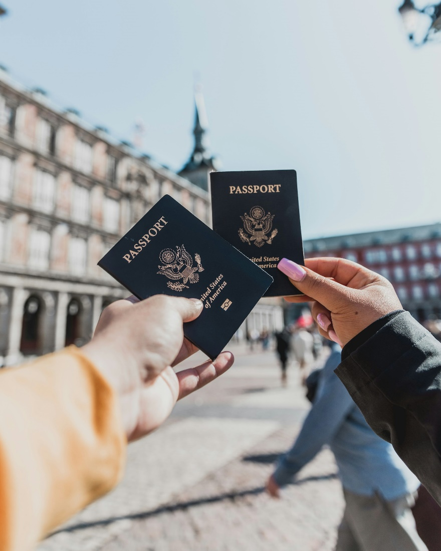 Two people holding up their passports. 