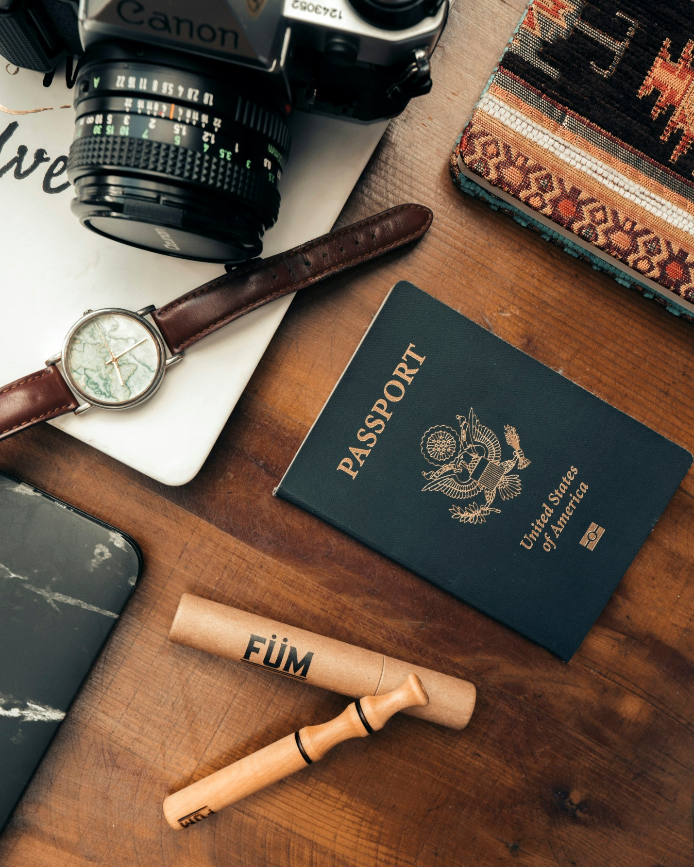 an American passport, along with multiple other items scattered on a wooden surface