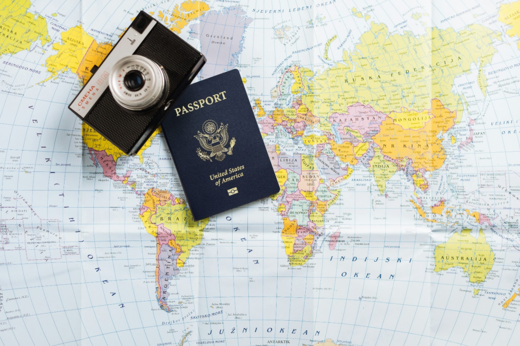 a passport placed alongside a camera on a world map