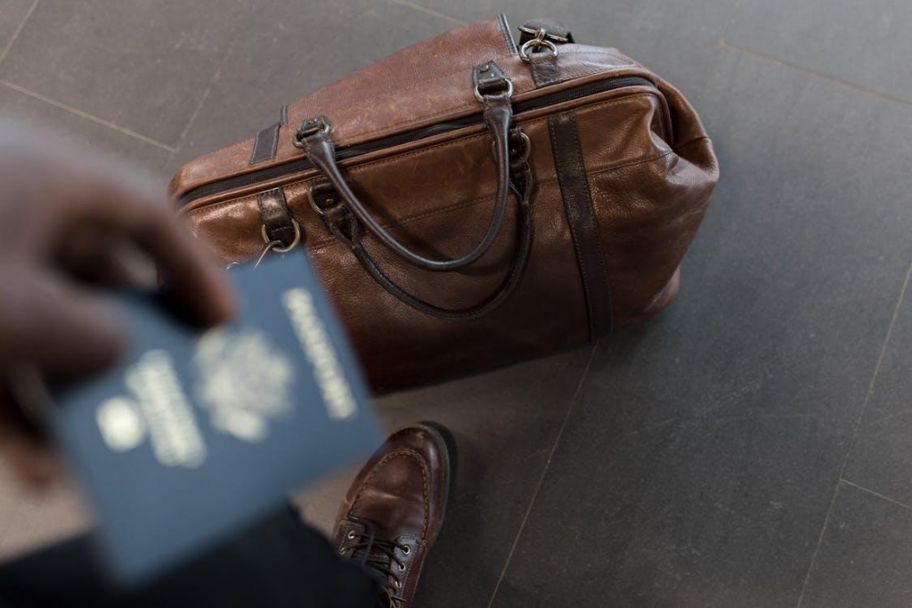 A stylish brown leather duffel bag, ideal for business travel with an emergency expedited passport.